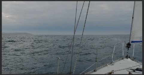 View ahead from a small boat showing a headland