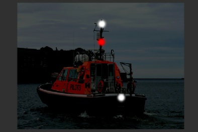 A vessel engaged in pilotage duties underway - seen from astern