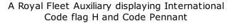 A Royal Fleet Auxiliary displaying International Code flag H and Code Pennant